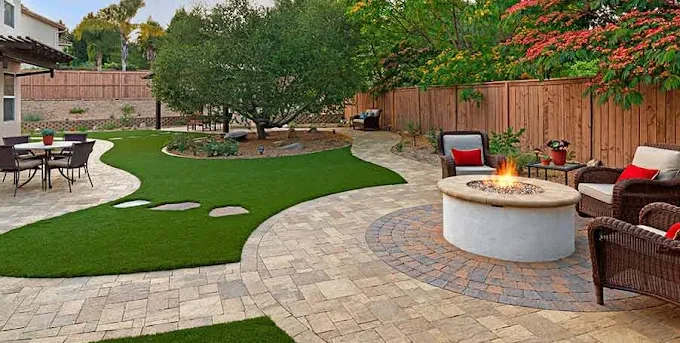 Backyard with paver patio, artificial turf lawn and a circular paver fire pit